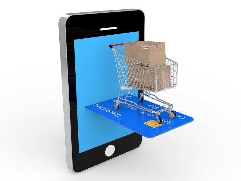 Smartphone mit einem Einkaufswagen voller Kartons auf einer Kreditkarte
