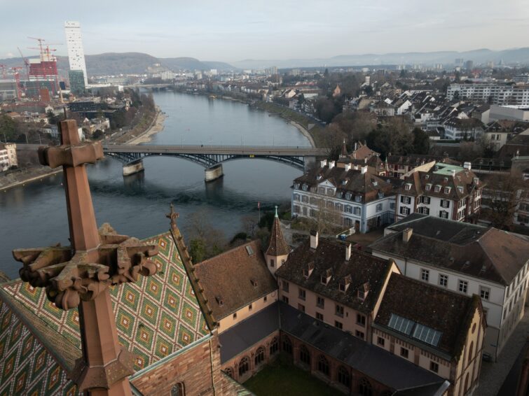 Blick auf die malerische Stadt Basel mit dem Rhein und der Mittleren Brücke, umrahmt von historischen Gebäuden und der beeindruckenden Architektur der Basler Münster. Entdecken Sie die kulturelle und architektonische Vielfalt Basels