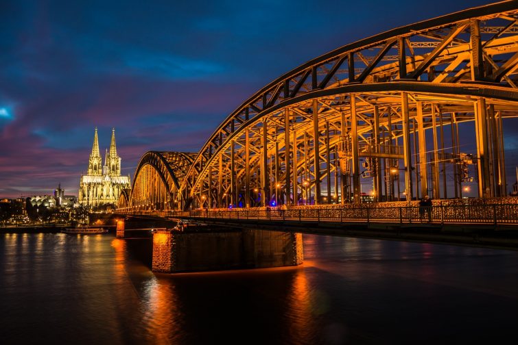 Die spektakuläre Ansicht des Kölner Doms und der Hohenzollernbrücke bei Nacht, ein Muss für jeden, der nach Köln zieht. Diese ikonischen Wahrzeichen sind Symbole der Stadt und bieten faszinierende kulturelle Erlebnisse.